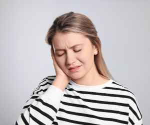 Woman experiencing earache and holding her ear. ear infection treatment whitwell